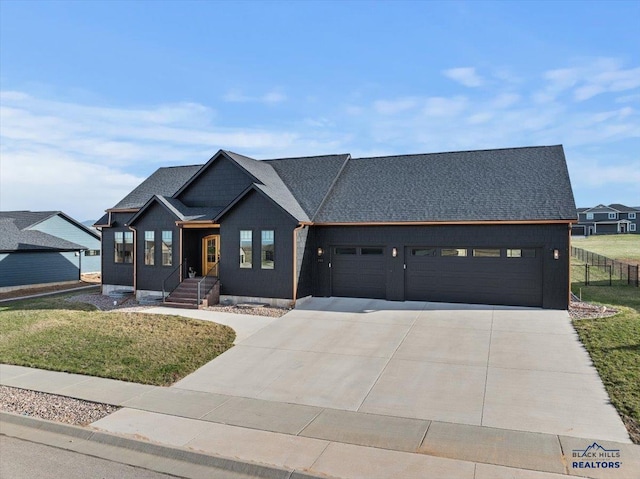 view of front of home with driveway, fence, a garage, and a front lawn