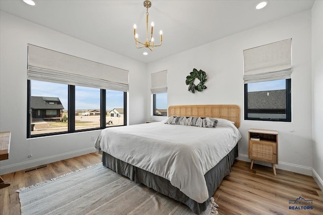 bedroom with visible vents, baseboards, a chandelier, recessed lighting, and wood finished floors