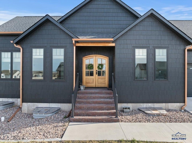 view of front of home with french doors and a shingled roof