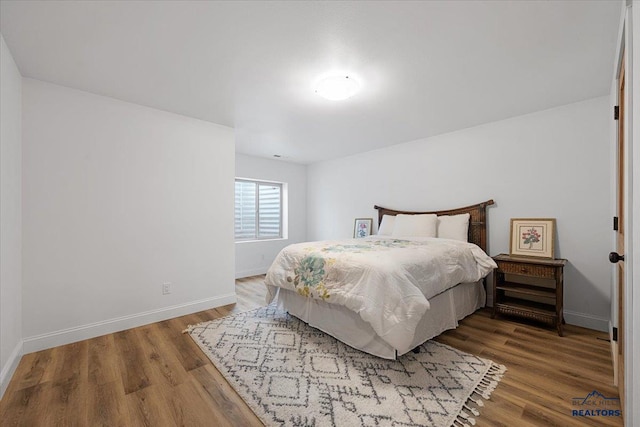 bedroom featuring wood finished floors and baseboards