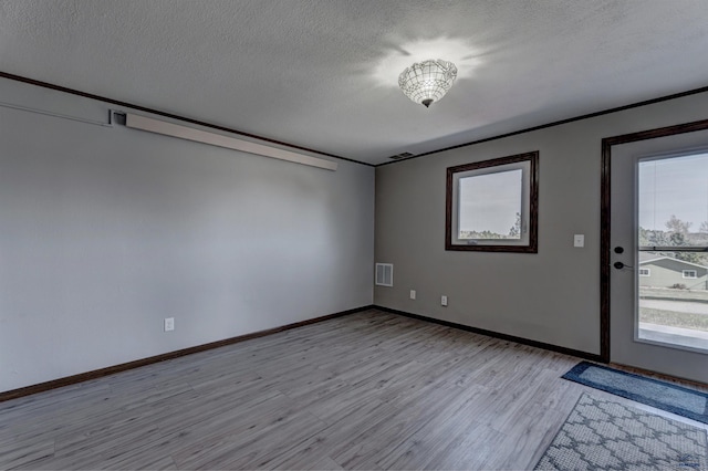 7497 Tanager Dr, Rapid City, SD 57702 - empty room with baseboards, light wood-style flooring, a textured ceiling, and visible vents