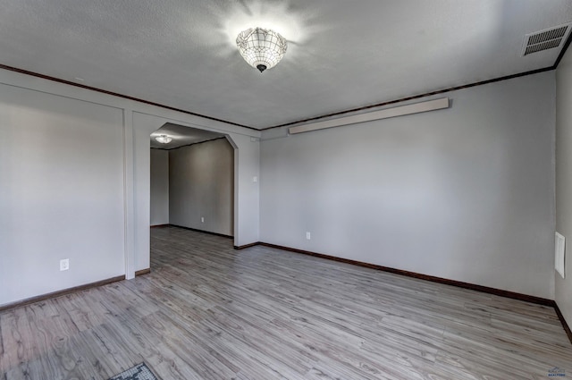 7497 Tanager Dr, Rapid City, SD 57702 - spare room featuring arched walkways, baseboards, visible vents, and light wood-type flooring