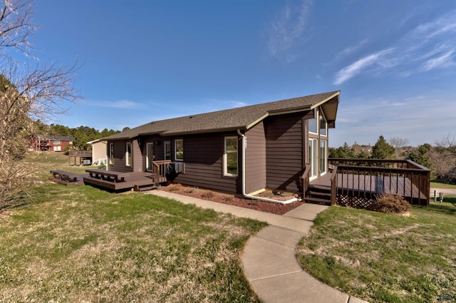 7497 Tanager Dr, Rapid City, SD 57702 - rear view of property with roof with shingles, a wooden deck, and a lawn