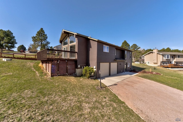 7497 Tanager Dr, Rapid City, SD 57702 - view of side of home featuring concrete driveway, a yard, a wooden deck, and an attached garage