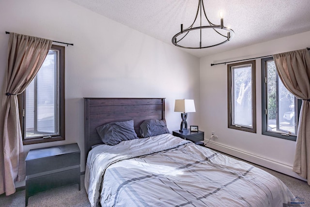 carpeted bedroom with a baseboard radiator, a textured ceiling, and an inviting chandelier