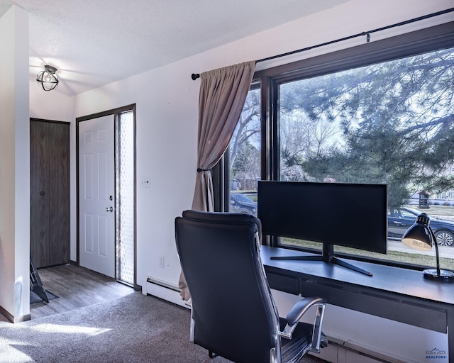 office area with carpet floors, baseboards, and a baseboard heating unit