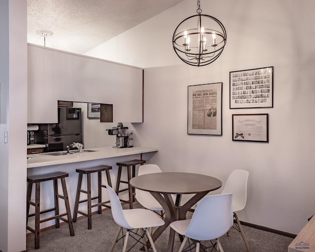 dining room featuring baseboards, carpet flooring, a chandelier, and vaulted ceiling