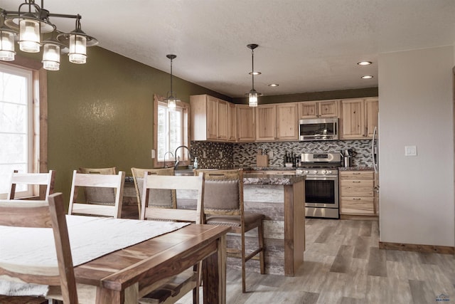 2412 Cameron Dr, Rapid City, SD 57702 - kitchen with light wood-style flooring, light brown cabinets, decorative backsplash, and appliances with stainless steel finishes