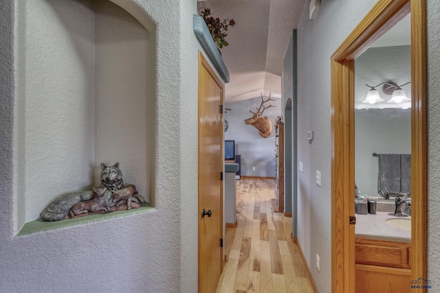 2906 Benjamin, Rapid City, SD 57703 - hallway featuring light wood-style floors, a textured wall, and a sink