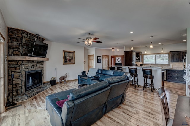 20694 Roosevelt Ct, Sturgis, SD 57785 - living room with a stone fireplace, light wood-type flooring, recessed lighting, and a ceiling fan