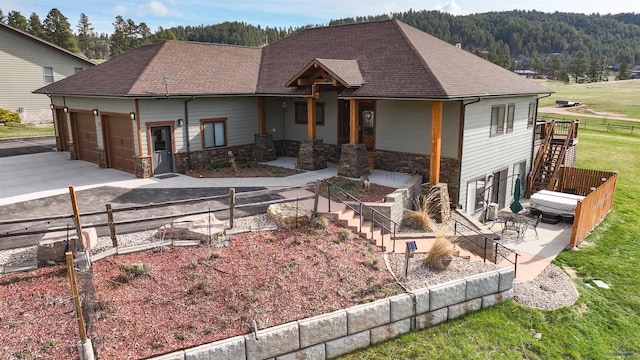 20694 Roosevelt Ct, Sturgis, SD 57785 - ranch-style house with a shingled roof, stone siding, a garage, stairway, and driveway