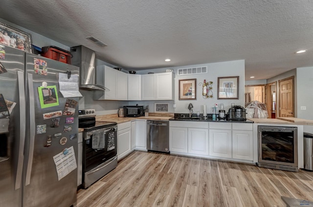 20694 Roosevelt Ct, Sturgis, SD 57785 - kitchen with wall chimney exhaust hood, beverage cooler, visible vents, and stainless steel appliances
