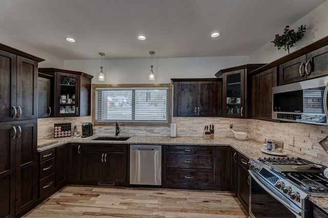 20694 Roosevelt Ct, Sturgis, SD 57785 - kitchen featuring tasteful backsplash, dark brown cabinetry, light stone counters, appliances with stainless steel finishes, and a sink
