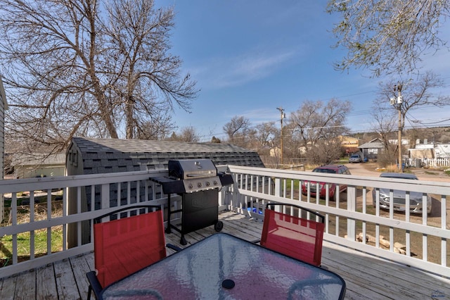 1021 Haines Ave, Rapid City, SD 57701 - deck with area for grilling, outdoor dining space, a storage shed, and an outbuilding