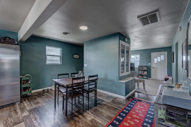 1021 Haines Ave, Rapid City, SD 57701 - dining area with visible vents, baseboards, wood finished floors, and a textured ceiling