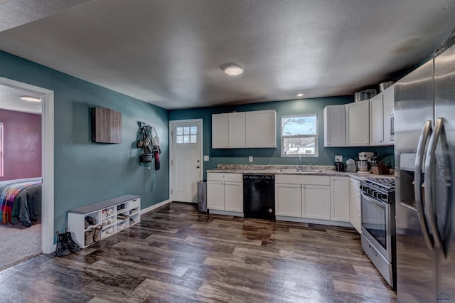 1021 Haines Ave, Rapid City, SD 57701 - kitchen with stainless steel appliances, dark wood-style flooring, white cabinets, and a sink