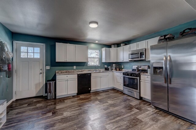 1021 Haines Ave, Rapid City, SD 57701 - kitchen with white cabinets, appliances with stainless steel finishes, plenty of natural light, and dark wood-style floors