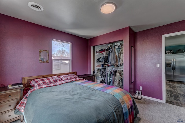 1021 Haines Ave, Rapid City, SD 57701 - carpeted bedroom with a closet, visible vents, stainless steel fridge, a textured wall, and baseboards
