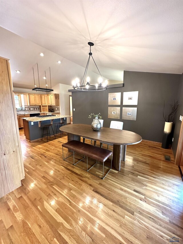 8000 Meadow View Ct, Rapid City, SD 57702 - dining area with light wood-style floors, visible vents, a notable chandelier, and lofted ceiling
