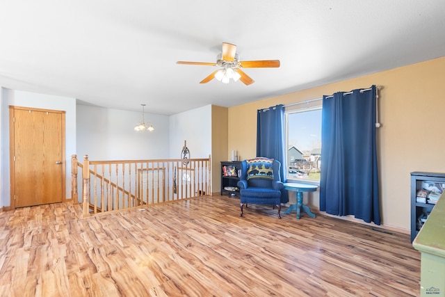 323 Freiheit Ln, Box Elder, SD 57719 - living area with an upstairs landing, wood finished floors, and ceiling fan with notable chandelier