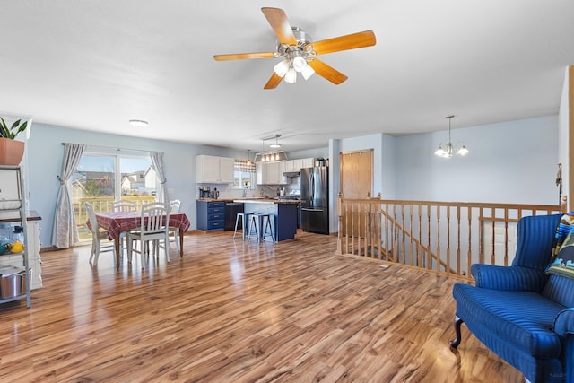 323 Freiheit Ln, Box Elder, SD 57719 - living room featuring light wood-type flooring and ceiling fan with notable chandelier