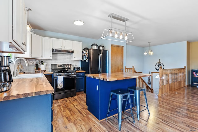 323 Freiheit Ln, Box Elder, SD 57719 - kitchen featuring under cabinet range hood, wooden counters, a sink, and stainless steel appliances