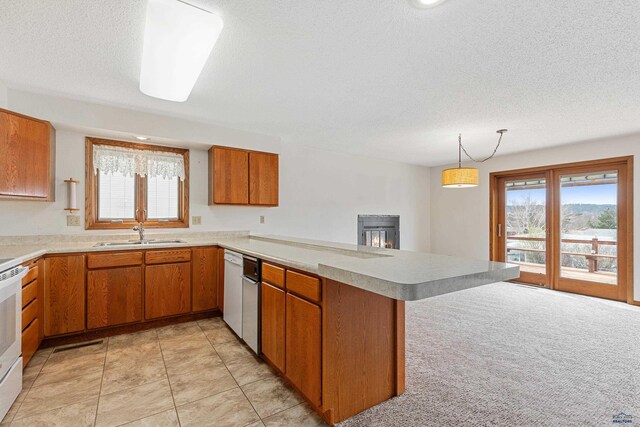 2713 Harney Pl, Rapid City, SD 57702 - kitchen with brown cabinetry, a peninsula, light countertops, and a sink