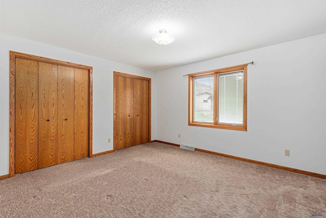 2713 Harney Pl, Rapid City, SD 57702 - unfurnished bedroom featuring carpet flooring, visible vents, baseboards, and multiple closets