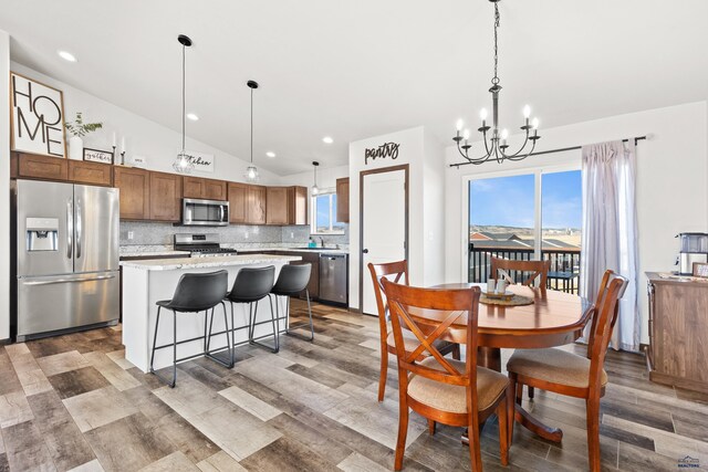 4425 Beringer Dr, Rapid City, SD 57703 - dining space featuring lofted ceiling, a chandelier, wood finished floors, healthy amount of natural light, and recessed lighting