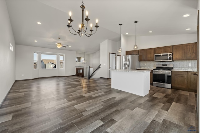 4425 Beringer Dr, Rapid City, SD 57703 - kitchen with stainless steel appliances, a chandelier, a kitchen island, decorative backsplash, and dark wood finished floors