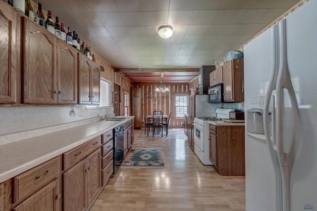 101/109 Sherman St, Rapid City, SD 57702 - kitchen with a sink, light wood-style floors, a notable chandelier, white appliances, and light countertops