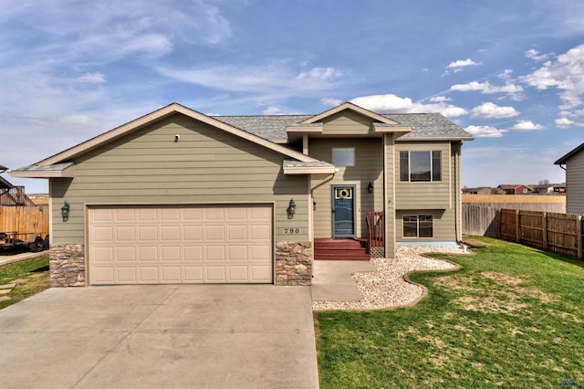 view of front facade with fence, stone siding, driveway, and a front yard