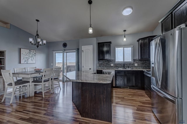 kitchen with a wealth of natural light, backsplash, appliances with stainless steel finishes, and dark wood finished floors