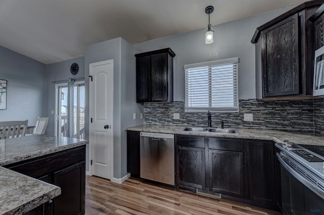 kitchen with decorative backsplash, appliances with stainless steel finishes, a sink, and a healthy amount of sunlight