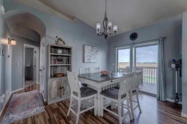 dining area with arched walkways, lofted ceiling, a notable chandelier, and wood finished floors