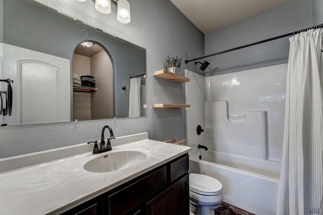 full bathroom featuring a textured wall, shower / tub combo, toilet, and vanity