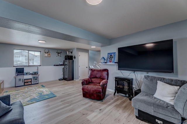 living area with a wood stove and light wood-style flooring