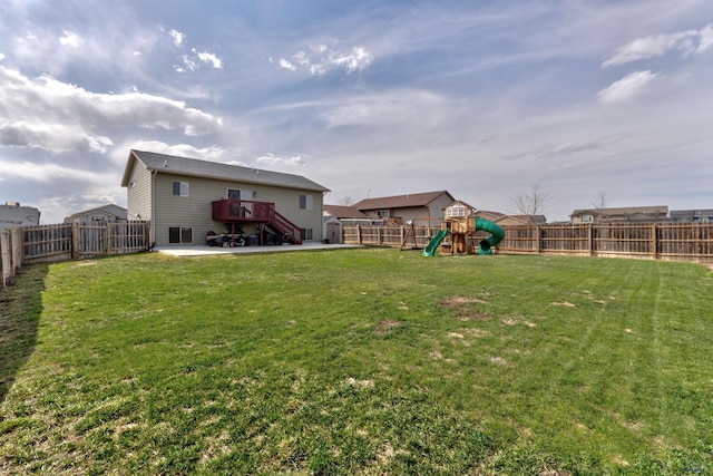 view of yard featuring a fenced backyard, a playground, a patio area, stairs, and a deck