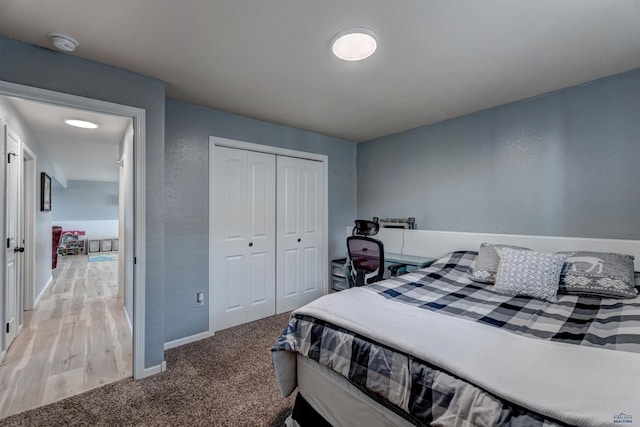 bedroom featuring a closet, baseboards, and light carpet