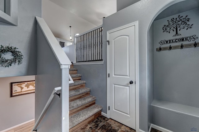 stairs with baseboards and arched walkways