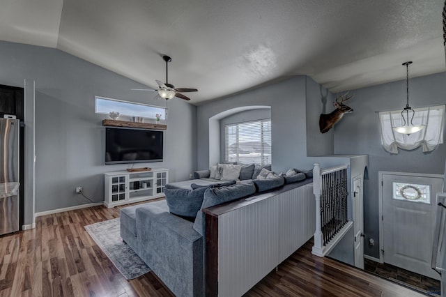 living room featuring lofted ceiling, baseboards, wood finished floors, and ceiling fan