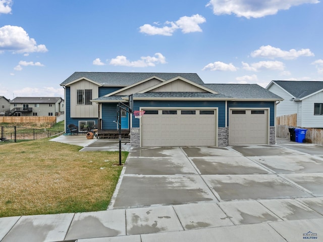 701 Haakon St, Rapid City, SD 57703 - view of front of property featuring a front lawn, driveway, stone siding, board and batten siding, and an attached garage