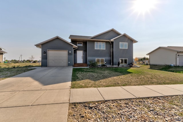 split level home with an attached garage, a front yard, and concrete driveway