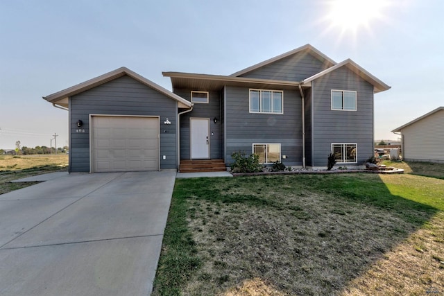 view of front facade featuring an attached garage, a front lawn, and concrete driveway