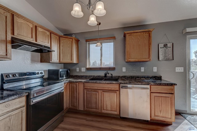 kitchen with under cabinet range hood, dark countertops, wood finished floors, a sink, and appliances with stainless steel finishes