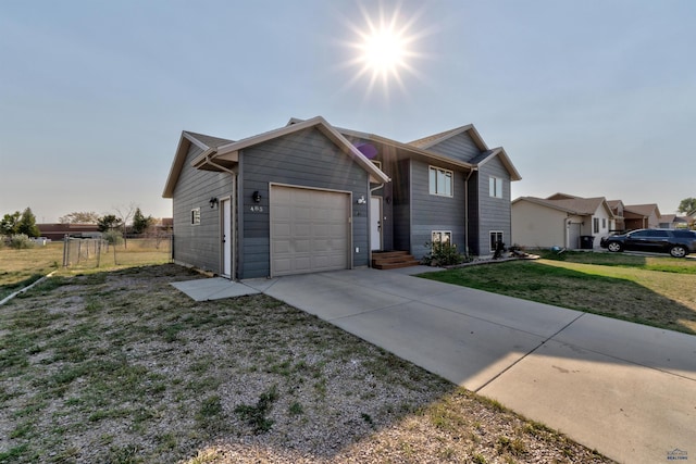 view of front facade featuring concrete driveway, an attached garage, fence, and a front lawn