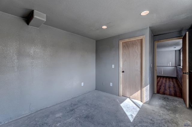 unfurnished bedroom with a closet and unfinished concrete flooring