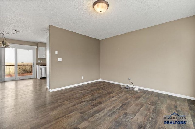 spare room with baseboards, dark wood-type flooring, and a textured ceiling