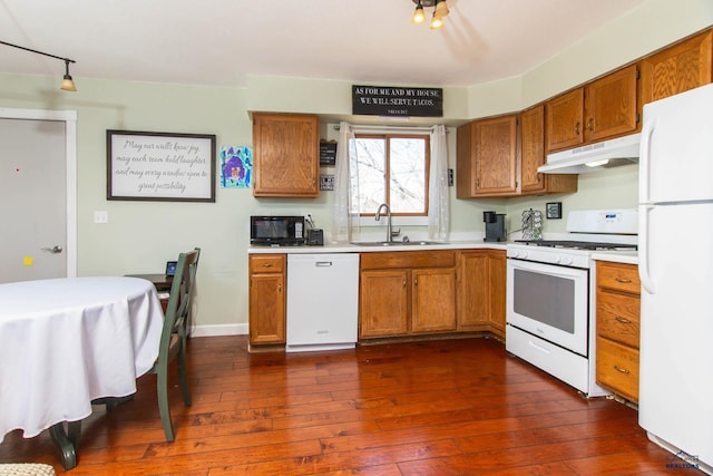 1711 Plateau Ln, Rapid City, SD 57703 - kitchen featuring brown cabinets, under cabinet range hood, light countertops, a sink, and white appliances