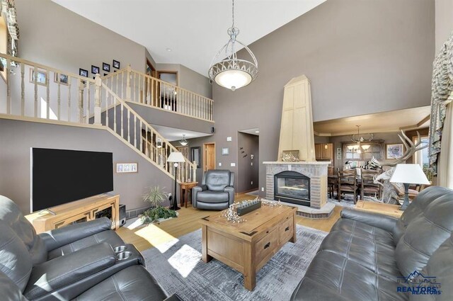 5325 Snowberry Ct, Rapid City, SD 57702 - living area with wood finished floors, a towering ceiling, stairway, and a brick fireplace